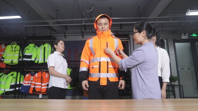 BOWINS team reviews a high visibility jacket prototype for a hi vis rainwear program